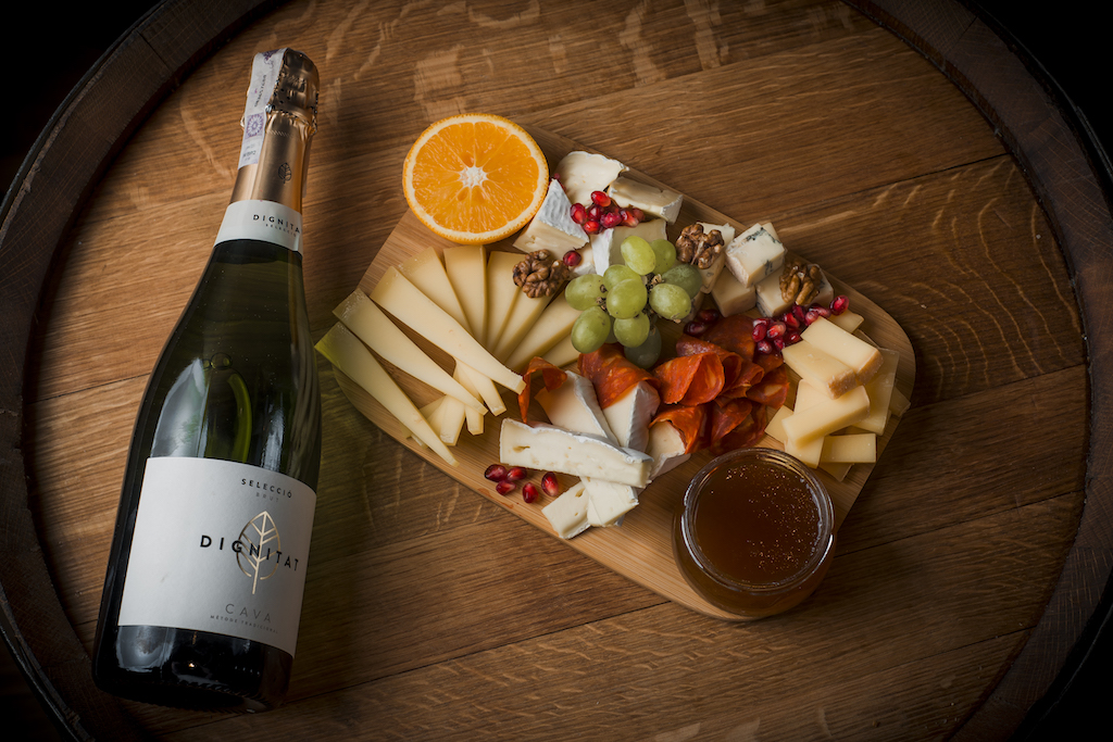 Tabla de quesos con acompañamientos y champán